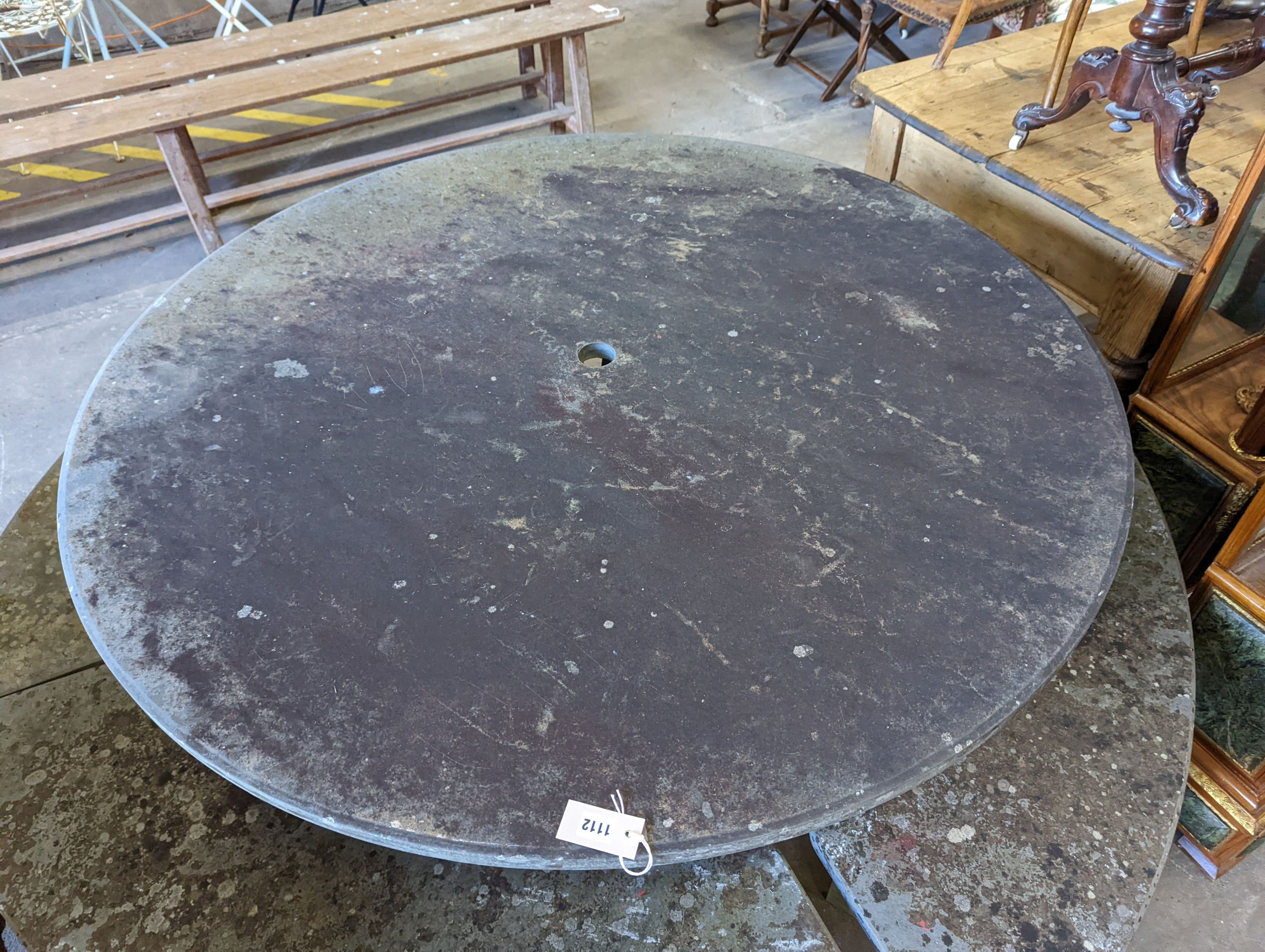 A heavy slate circular topped garden table, diameter 125cm, height 79cm together with four crescent shaped slate garden benches